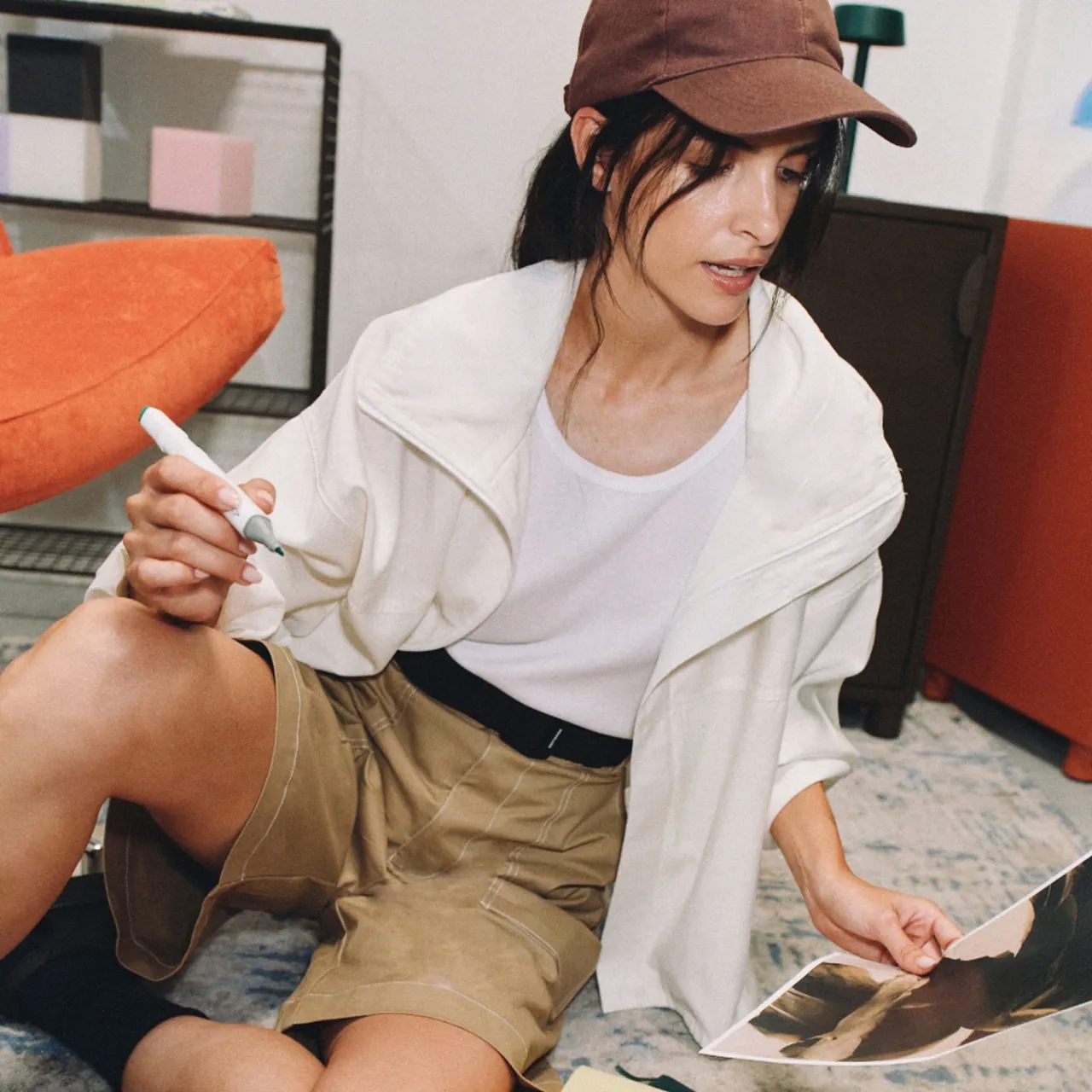 A woman on the floor choosing between printed versions of a design.